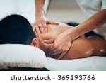 Sports massage. Massage therapist massaging shoulders of a male athlete, working with Trapezius muscle. Toned image