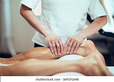 Sports Massage. Massage Therapist Working With Patient, Massaging His Calves. Toned Image.