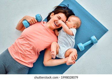 A sports mother is engaged with the child in fitness and yoga at home. The concept of sports, motherhood and an active lifestyle. Young woman in sports training with her child. - Powered by Shutterstock