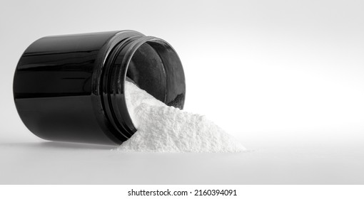 Sports Nutrition -  Protein. Measuring Spoon And White Medicinal Powder With Black Jar On White Background, Isolated. Nutritional Supplement Or Medicament, Medicine Treatment Concept