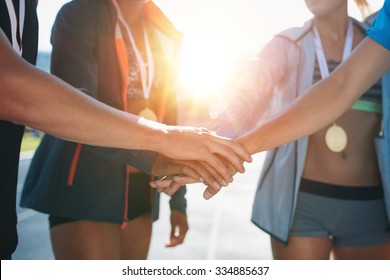 Sports People With Hands Together In Huddle. Team With Hands Together Celebrating Success After Winning Athletics Competition.