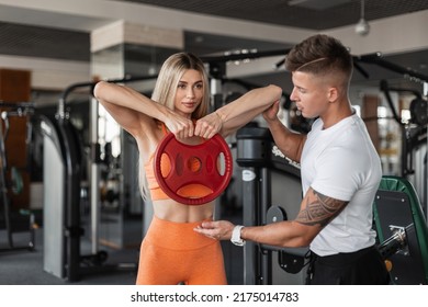 Sports Pretty Couple Man And Woman In Sports Fancy Dress Work Out Together In The Gym And Do Exercises