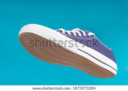 Sports shoe on blue background. Sneaker or trainer. Fitness, sport, training concept.