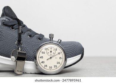 Sports shoes, whistle and stopwatch on gray background. Concept of time management - Powered by Shutterstock