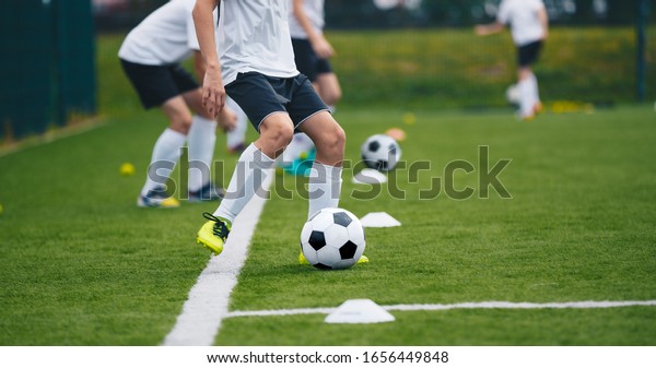 Sports Soccer Players on\
Training. Boys Kicking Soccer Balls on Practice Session. Kids\
Playing Soccer on Training Football Pitch. Beginner Soccer Drills\
for Juniors
