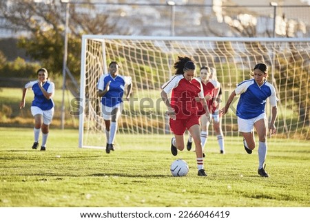 Sports team, girl soccer and kick ball on field in a tournament. Football, competition and athletic female teen group play game on grass. Fit adolescents compete to win match at school championship.