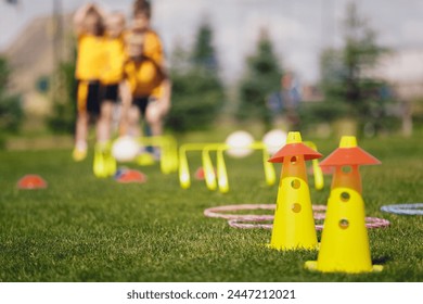 Sports traiing camp equipment for chldren. Young football players at summer practice camp. Kids at training obstacles course - Powered by Shutterstock