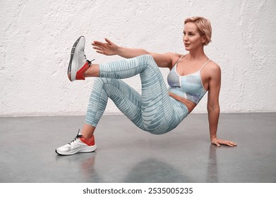 Sports training of a girl.Exercise gluteal bridge on straight hand with lifting legs up and touching the palm of the opposite leg bent at the knee.Athletic girl performs muscle strengthening exercises - Powered by Shutterstock