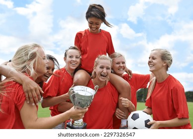 Sports, trophy and women soccer team winner celebrating victory, achievement and match success on field. Football, prize and girl group lifting champion for celebration, competition or training goal - Powered by Shutterstock