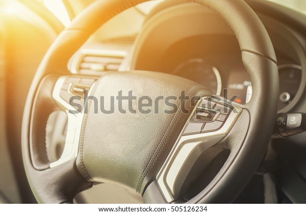 Sports vehicle\
interior with black salon,Modern new car illuminated dashboard and\
steering wheel and  airbag on the front of the car,selective\
focus,vintage\
color\
\
\
