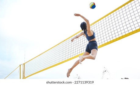 Sports, volleyball and woman jump at beach to hit ball in competition, game or match. Training, exercise and female athlete jumping for spike in tournament for workout, fitness and health at seashore - Powered by Shutterstock