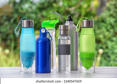 Sports Water Bottles On Table Against Blurred Background