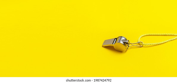 Sports whistle on yellow background. Concept- sport competition, referee, statistics, challenge. Basketball, handball, futsal, volleyball, soccer, baseball, football and hockey referee whistle