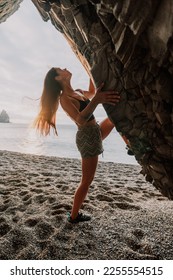 Sports Woman Climbing The Rock. Young woman With slim fit body climbing in volcanic basalt cave with beautiful sea view. The athlete girl trains in nature. Woman overcomes difficult climbing route. - Shutterstock ID 2255554515