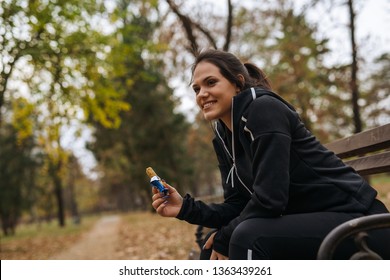 Sports Woman Eating Granola Bar In City Park