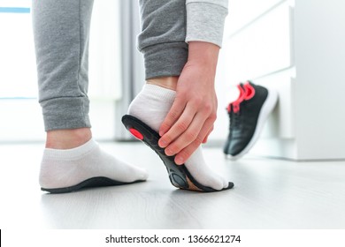 Sports woman fitting orthopedic insoles. Treatment and prevention of flat feet and foot orthopedic diseases. Foot care, feet comfort. Health care. Wearing sports comfortable shoes - Shutterstock ID 1366621274