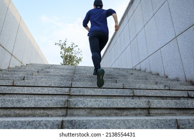 Sports woman running up stairs in city - Shutterstock ID 2138554431
