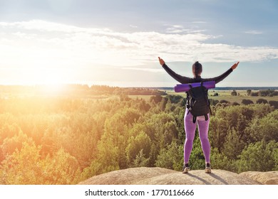 Sports Woman Single Hiker With Backpack Stands With His Back On Mountain And Looks Into Distance On Sun With Arms Raised, Concept Wellness Turist