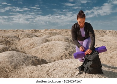 Sports Woman Single Hiker Sits On One Knee With Backpack On Mountain, Concept Turism, Wellness Turist