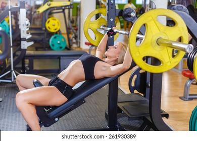 Sports Young Woman Doing Exercises With Barbell On Bench In The Gym.  Bar Bench Press.