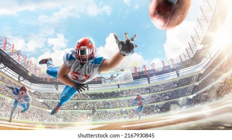 Sportsman in action. American football player catches the ball and flies in the air. Touchdown. American football in a large open stadium. Fans - Powered by Shutterstock