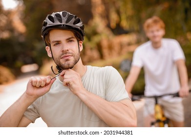 Sportsman adjusting the helmet straps before the bike ride - Powered by Shutterstock