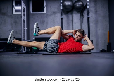 Sportsman doing bicycle lateral crunch workout at the gym. A hot male person in a fitness club doing sit-up exercises. Fitness goal, sport lover, legs extension - Powered by Shutterstock