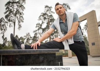 Sportsman During Outdoor Workout, Man Wearing Sports Outfit Warming Up Muscles, Doing Side Squat On One Leg, Enjoying Active Lifestyle Outside In Park