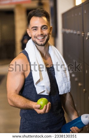 sportsman eating an apple after the training in the lockerroom
