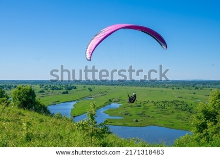 The sportsman flying on a paraglider. 
Paragliding take off. Travel destination. Summer and holiday concept. 