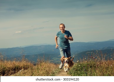 Sportsman has a mountain jogging walk with his beagle dog
