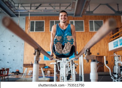 Sportsman Has Workout With Gymnastics Bar; Young Handsome Guy Exercising In Oldschool Gym;