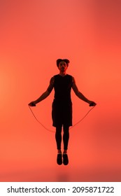 Sportsman Holding Skipping Rope While Jumping On Red Background