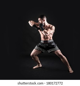 Sportsman Kick Boxer Full Body Portrait Against Black Background. 