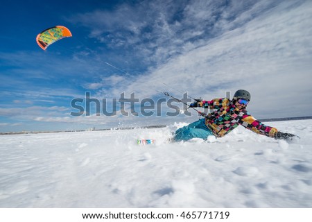 Sportsman is kiting on the background of snow and serene sky of Siberia