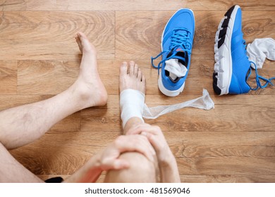 sportsman massaging his injured ankle after a sport accident