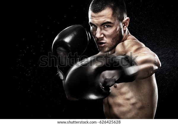 Sportsman muay thai boxer\
fighting in boxing cage. Isolated on black background with copy\
Space.