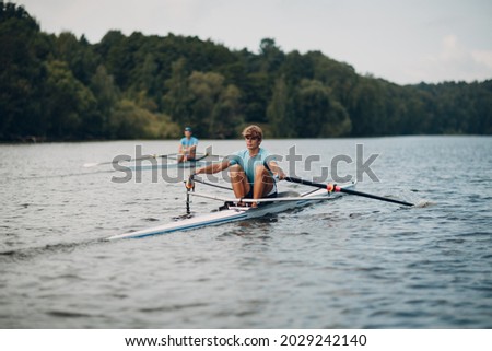 Sportsman oarsman single scull man rower rowing on boat oars.