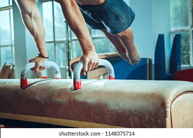 The sportsman performing difficult gymnastic exercise at gym. The sport, exercise, gymnast, health, training, athlete concept. Caucasian fit model - Powered by Shutterstock