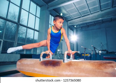 The sportsman performing difficult gymnastic exercise at gym. The sport, exercise, gymnast, health, training, athlete concept. Caucasian fit little boy