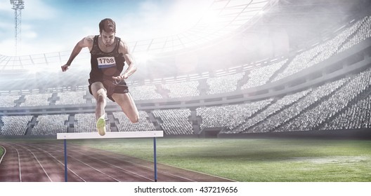 Sportsman practising hurdles against view of a stadium