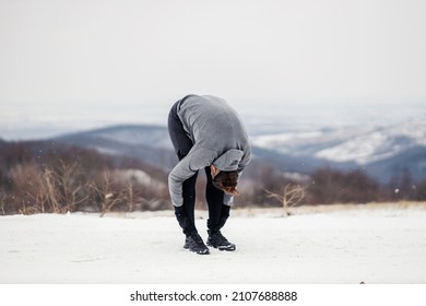 Sportsman In Shape Doing Stretching Exercises In Nature On Snowy Winter Day. Healthy Habits, Outdoor Fitness, Winter Fitness