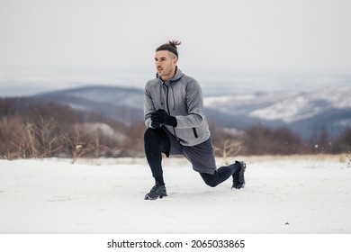 Sportsman In Shape Kneeling And Doing Warmup And Stretching Exercises On The Snow At Winter. Winter Fitness, Cold Weather, Warmup