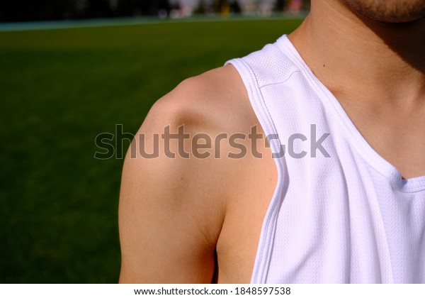 sportsman with shoulder dislocation in\
turf/sports field. shoulder bone is clarified.\
