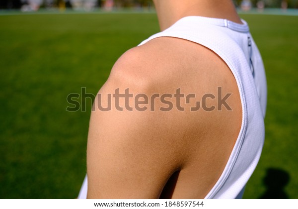 sportsman with shoulder dislocation in\
turf/sports field. shoulder bone is clarified.\
