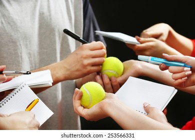 Sportsman Signing Autograph On Tennis Ball On Dark Background