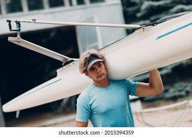 Sportsman single scull man rower carrying boat to competition - Powered by Shutterstock