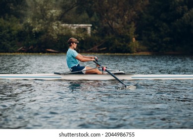 Sportsman single scull man rower rowing technique on boat. Paddle oar splash movement motion - Powered by Shutterstock