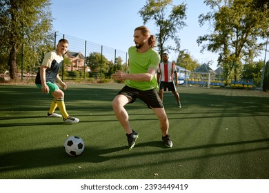 Sportsman team playing football on field at countryside - Powered by Shutterstock