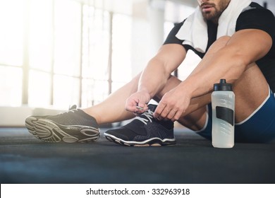 Sportsman ties his black sneakers - Powered by Shutterstock